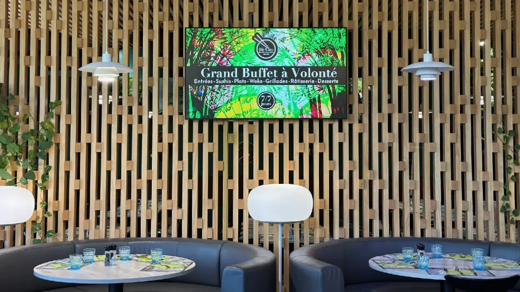 Écran d'affichage dynamique fixé au mur de la salle d'un restaurant