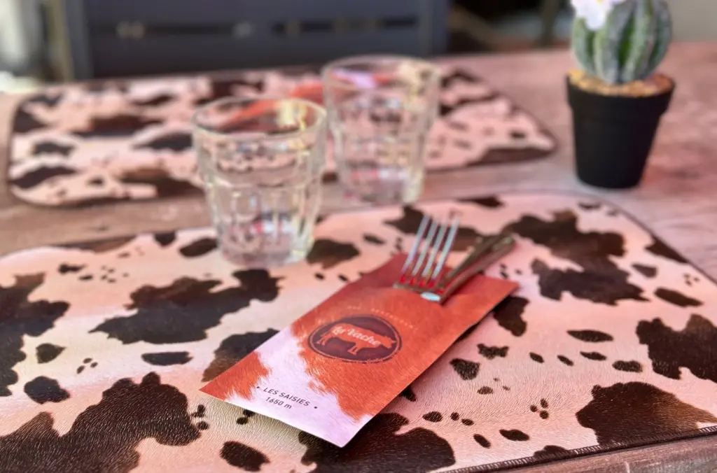 Table dressée avec set de table et pochette à couverts personnalisés, restaurant La Vache aux Saisies